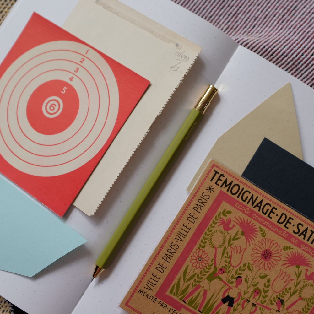 Collection of stationery items including cards and a pen on a textured surface